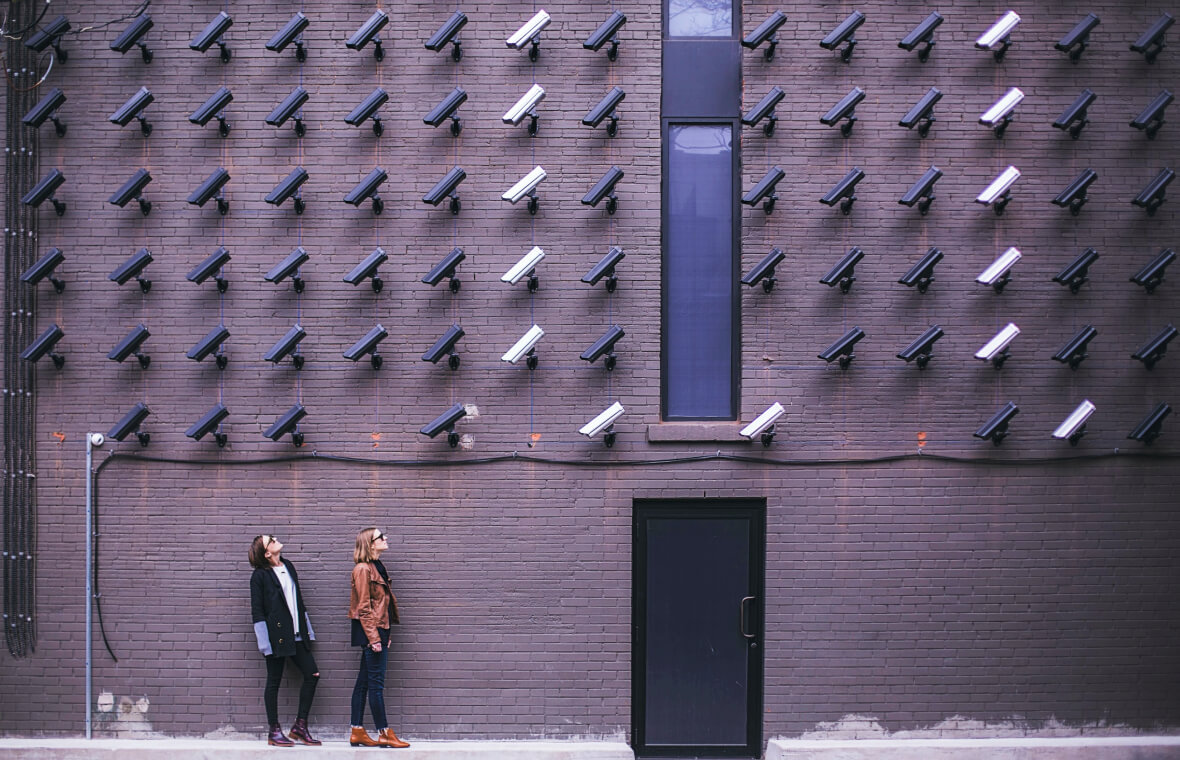 Security cameras surveil people on the streets.