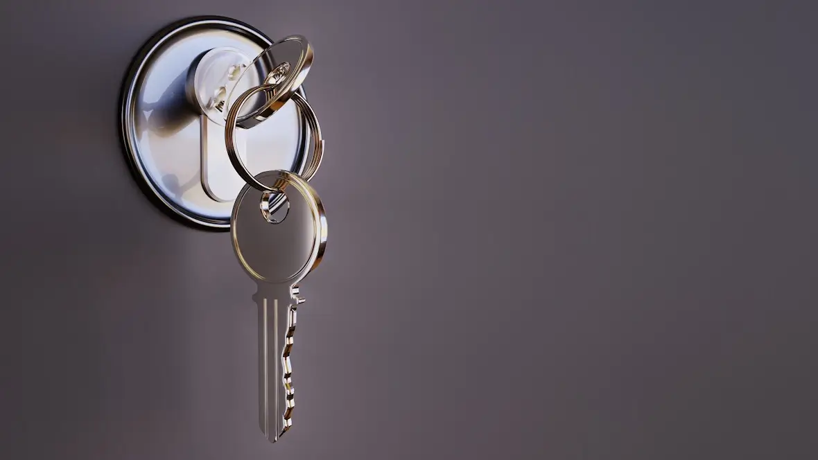 A photo of a key inside a lock on a gray background.