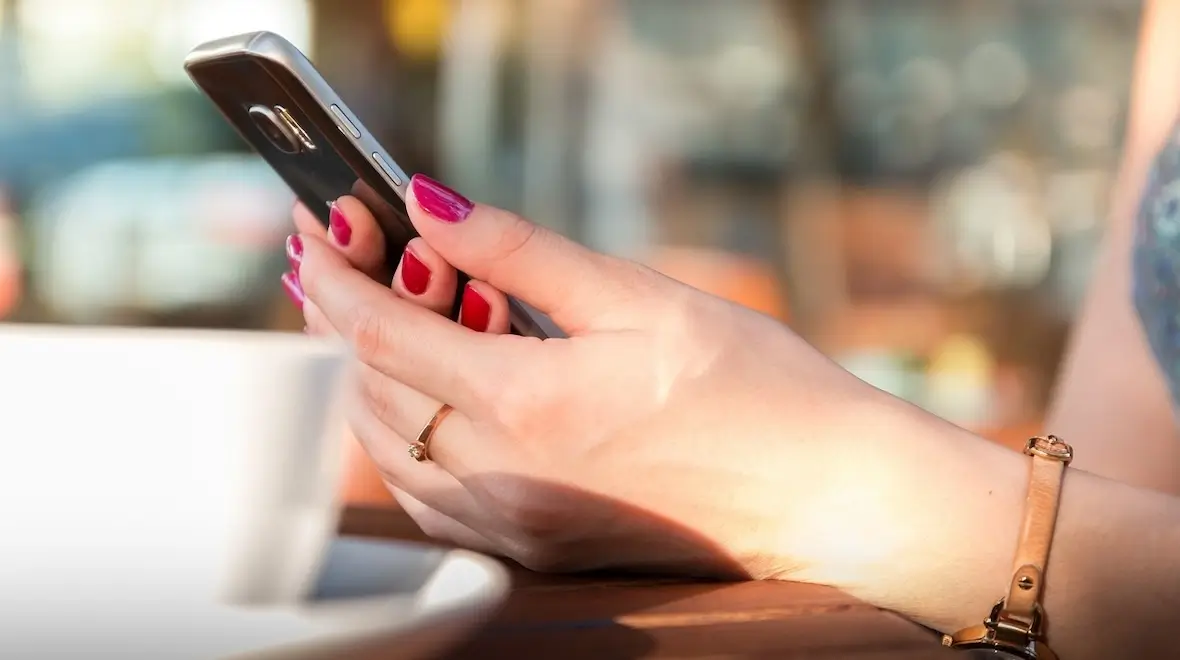 A photo of a person holding a mobile phone.