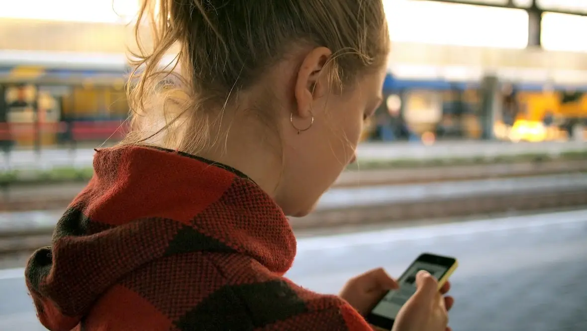 A photo of a girl texting on a smartphone.