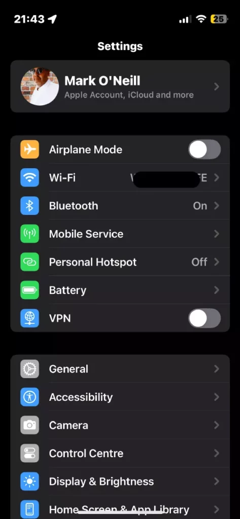 iPhone settings menu with user account and connectivity options.