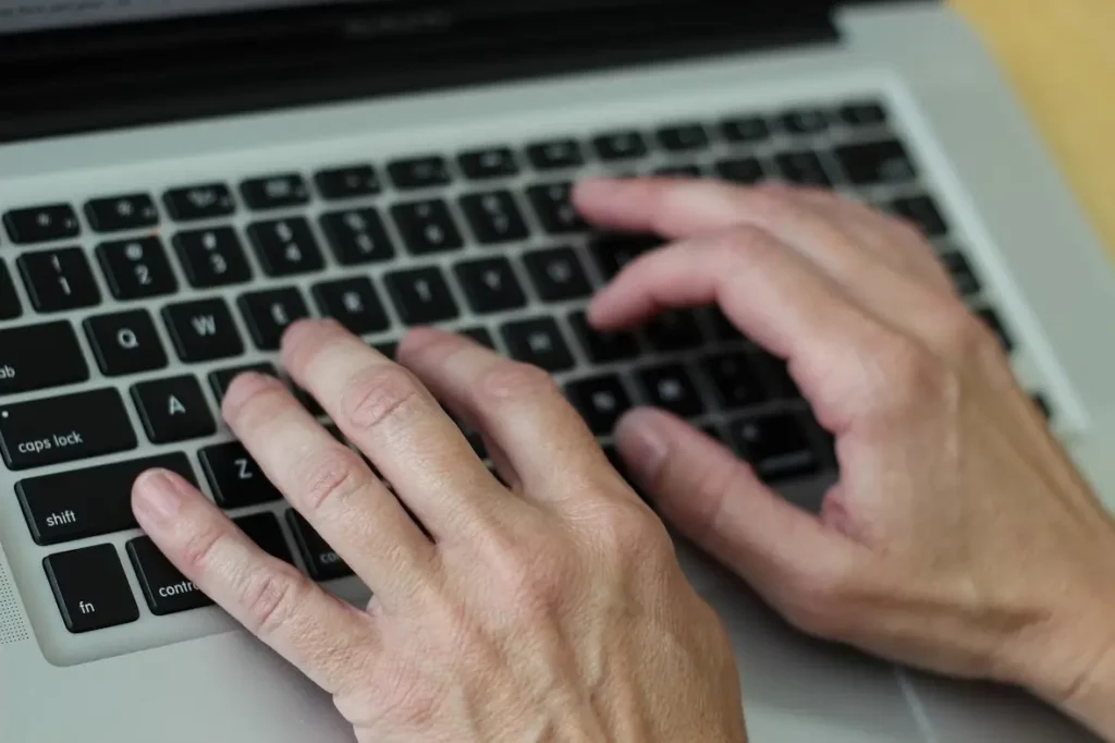 A photo of someone typing on a laptop keyboard.