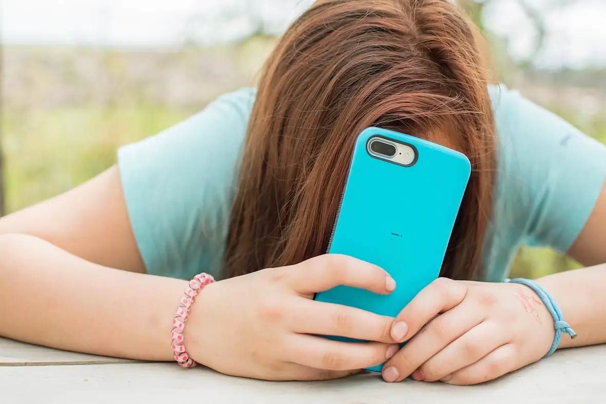 A photo of a teenager with an iPhone.