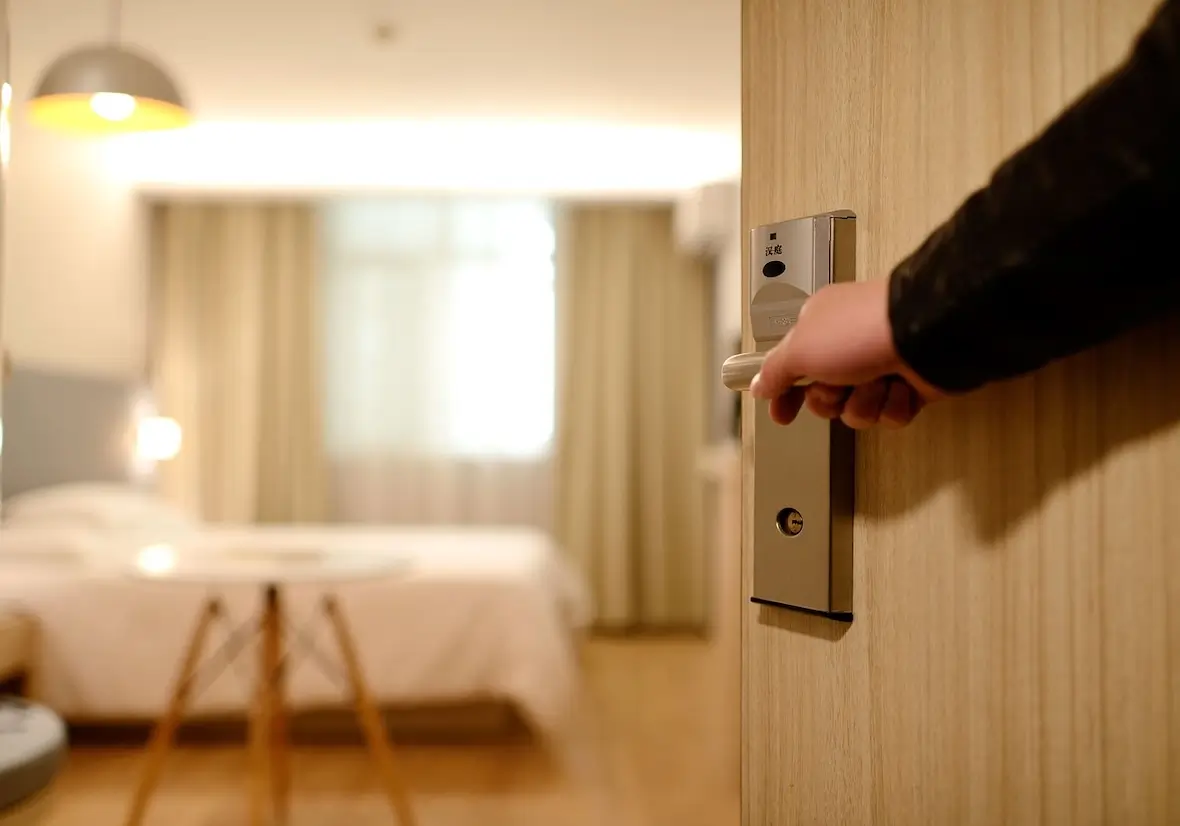 An image of a person opening up a hotel room door.