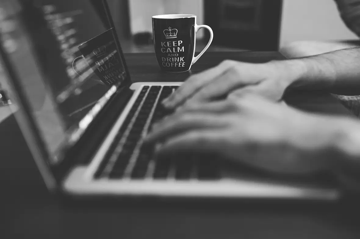 A photo of a person typing on a MacBook.