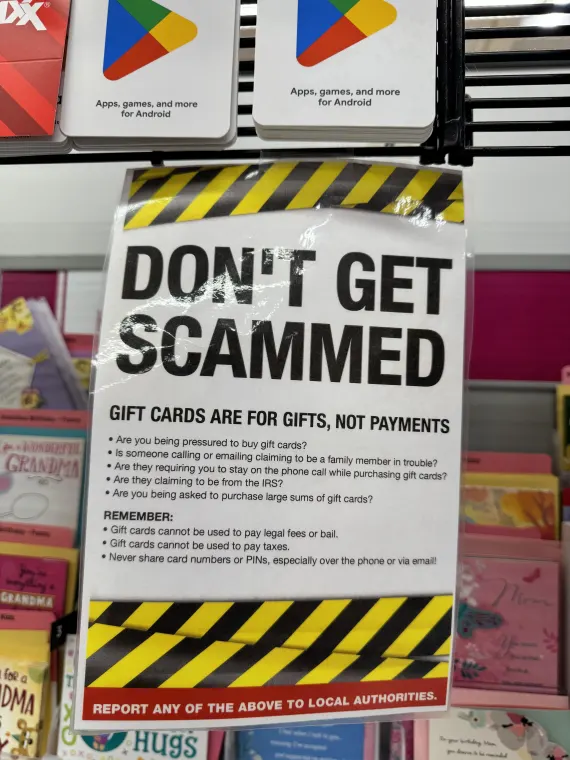 A photo of a "Don't Get Scammed" warning for customers shopping for gift cards.