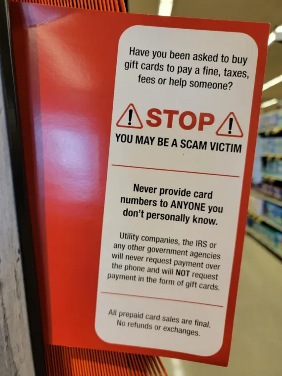 A photo of a "You May Be a Scam Victim" warning related to gift cards.